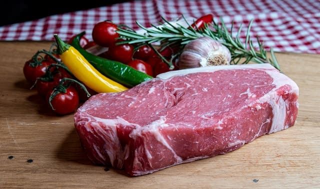 Rumpsteak mit Gemüse und Rosmarinzweig auf Holzbrett